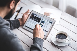 image of man reading a book on a tablet